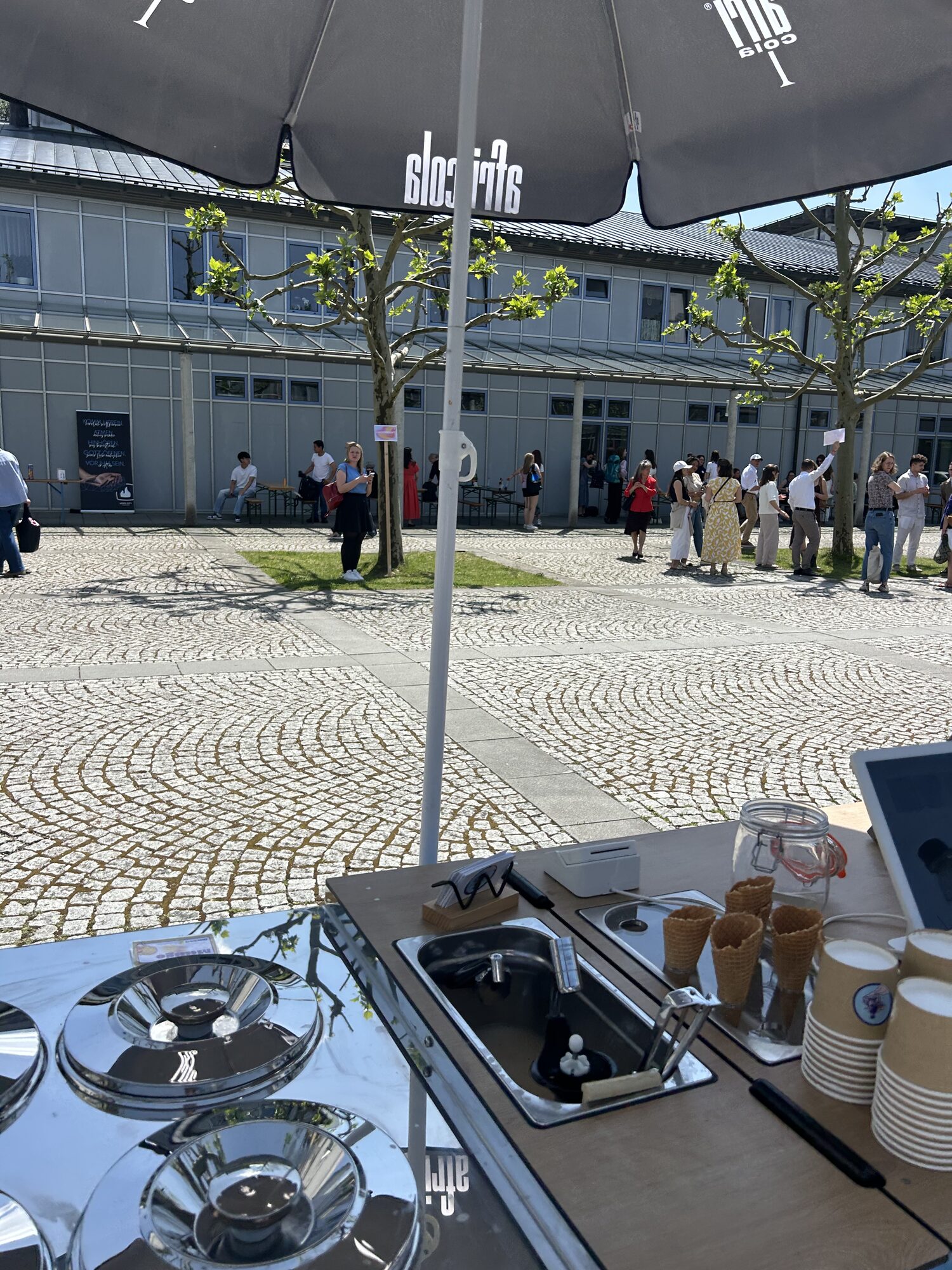 Eiszeitmobil vor Café auf sonnigem Platz in München